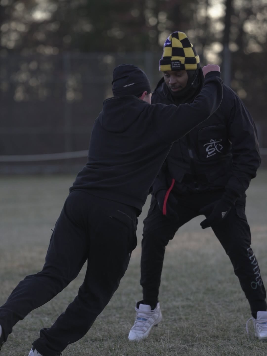 Coach working with an athlete during a winter football drill